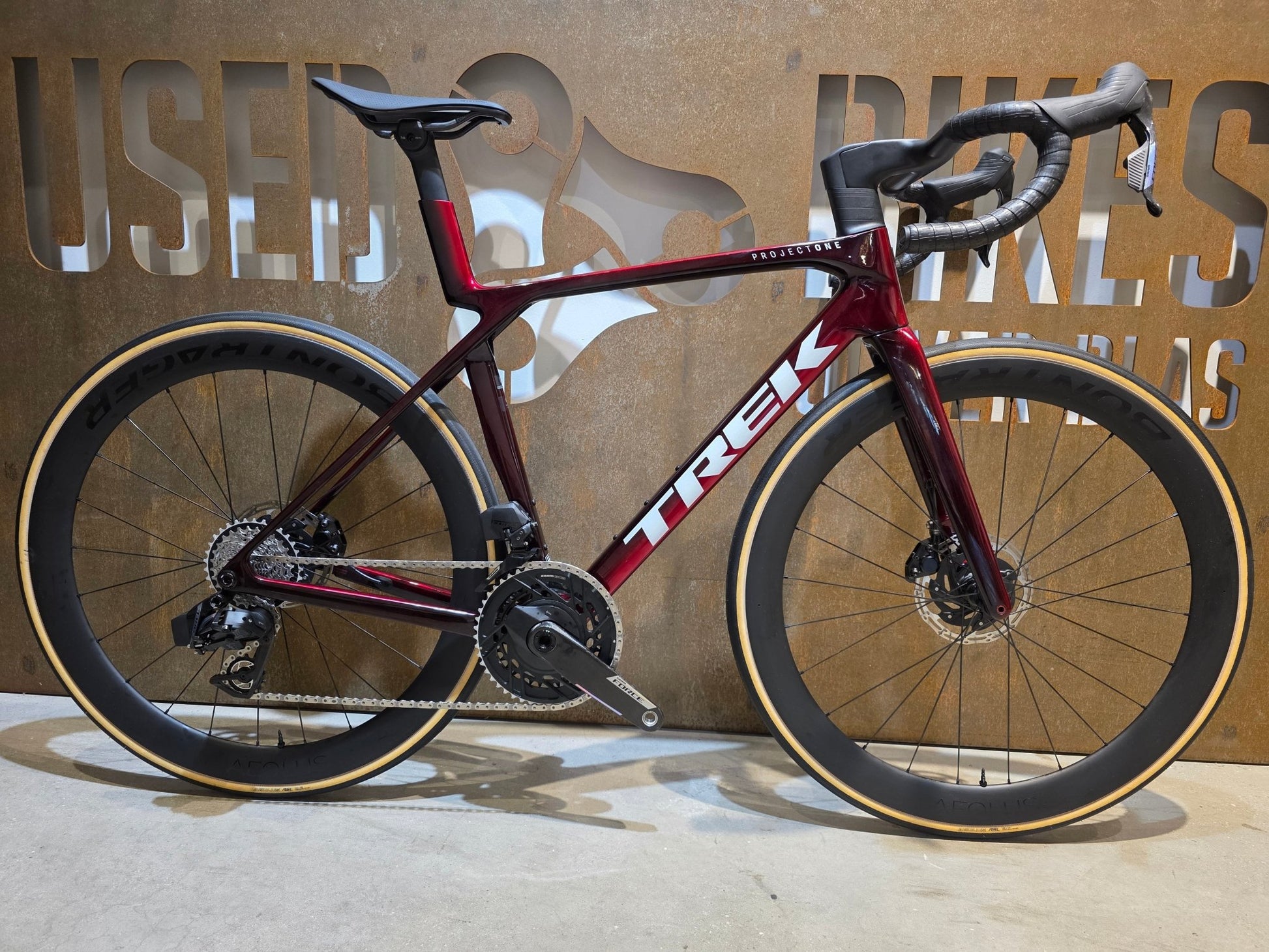 Rennrad von Trek, TREK MADONE SLR 7 AXS MY 2026 / CARBON RED SMOKE / M vor USEDBIKES - OB.DE Hintergrund