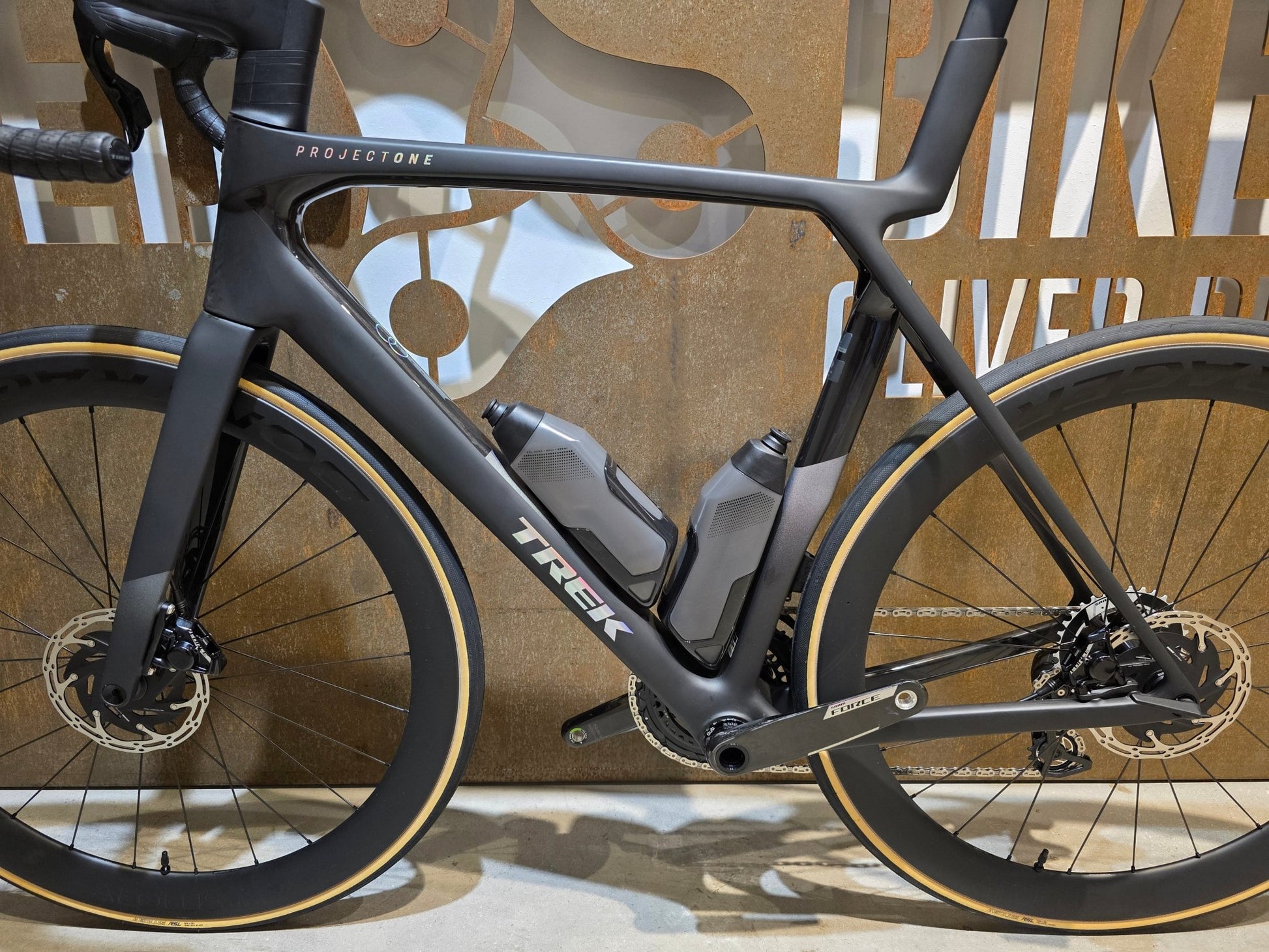 Rennrad von Trek, TREK MADONE SLR 7 AXS MY 2026 / MATTE CARBON SMOKE / L vor USEDBIKES - OB.DE Hintergrund