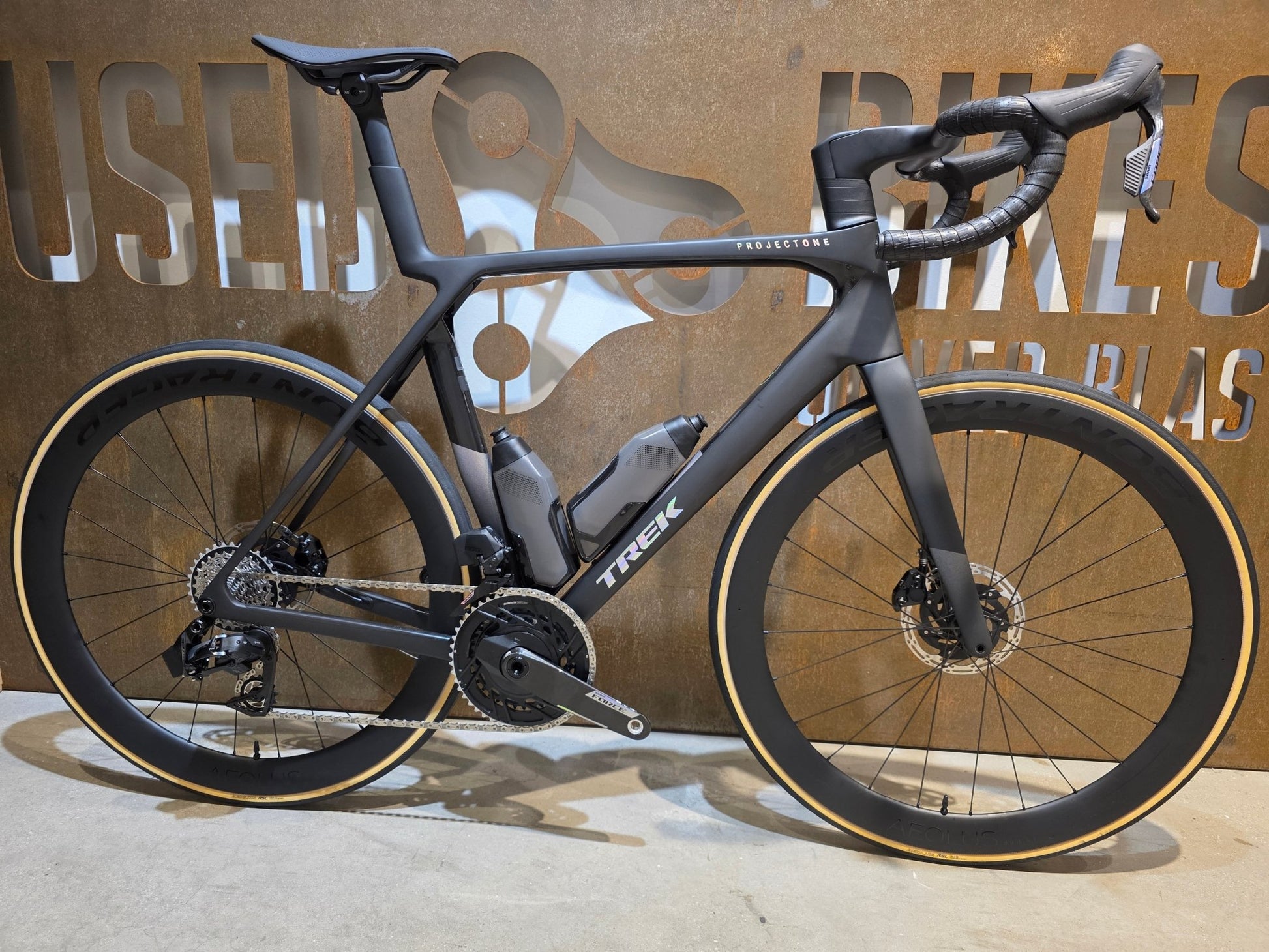 Rennrad von Trek, TREK MADONE SLR 7 AXS MY 2026 / MATTE CARBON SMOKE / L vor USEDBIKES - OB.DE Hintergrund