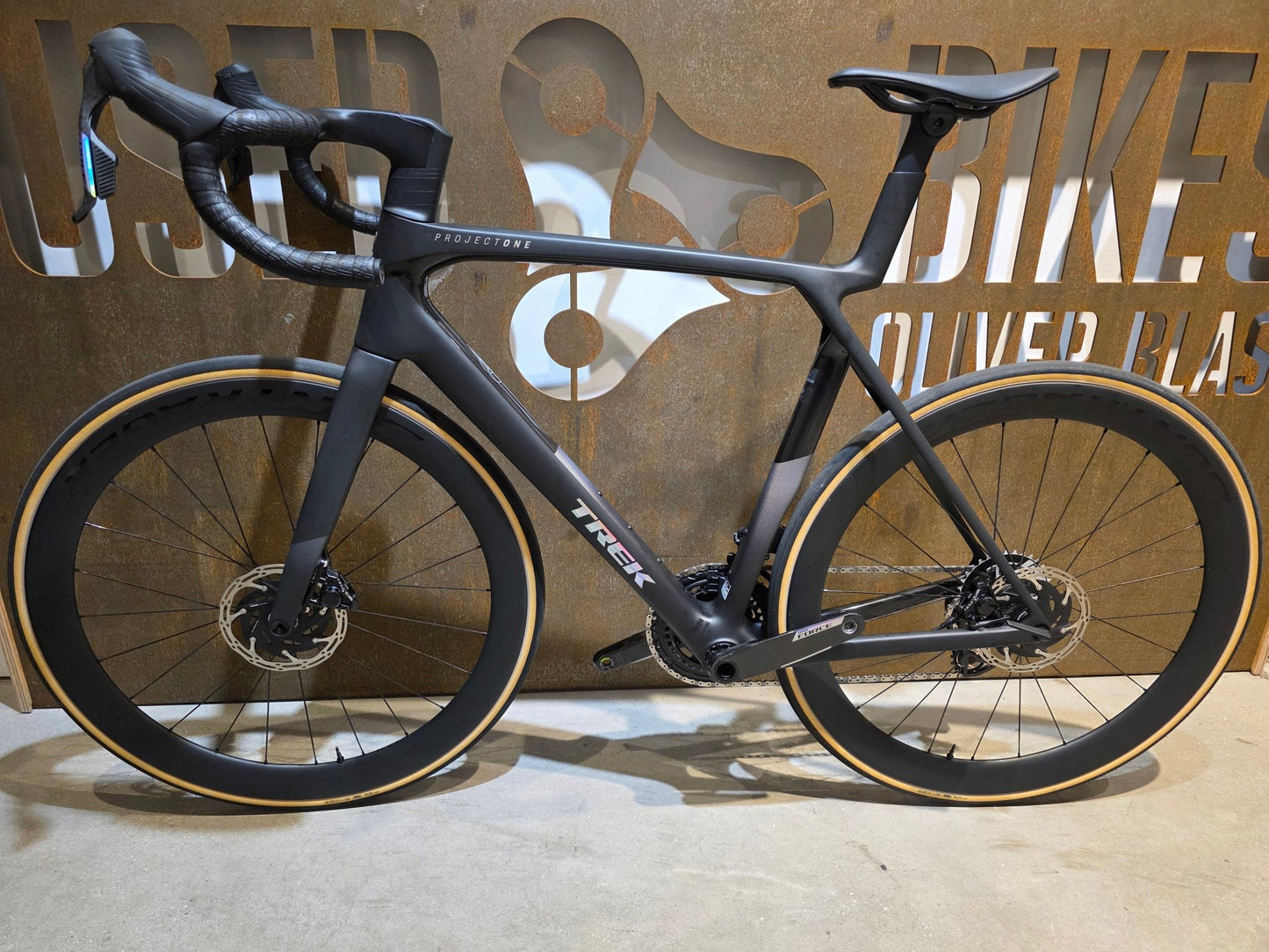 Rennrad von Trek, TREK MADONE SLR 7 AXS MY 2026 / MATTE CARBON SMOKE / L vor USEDBIKES - OB.DE Hintergrund