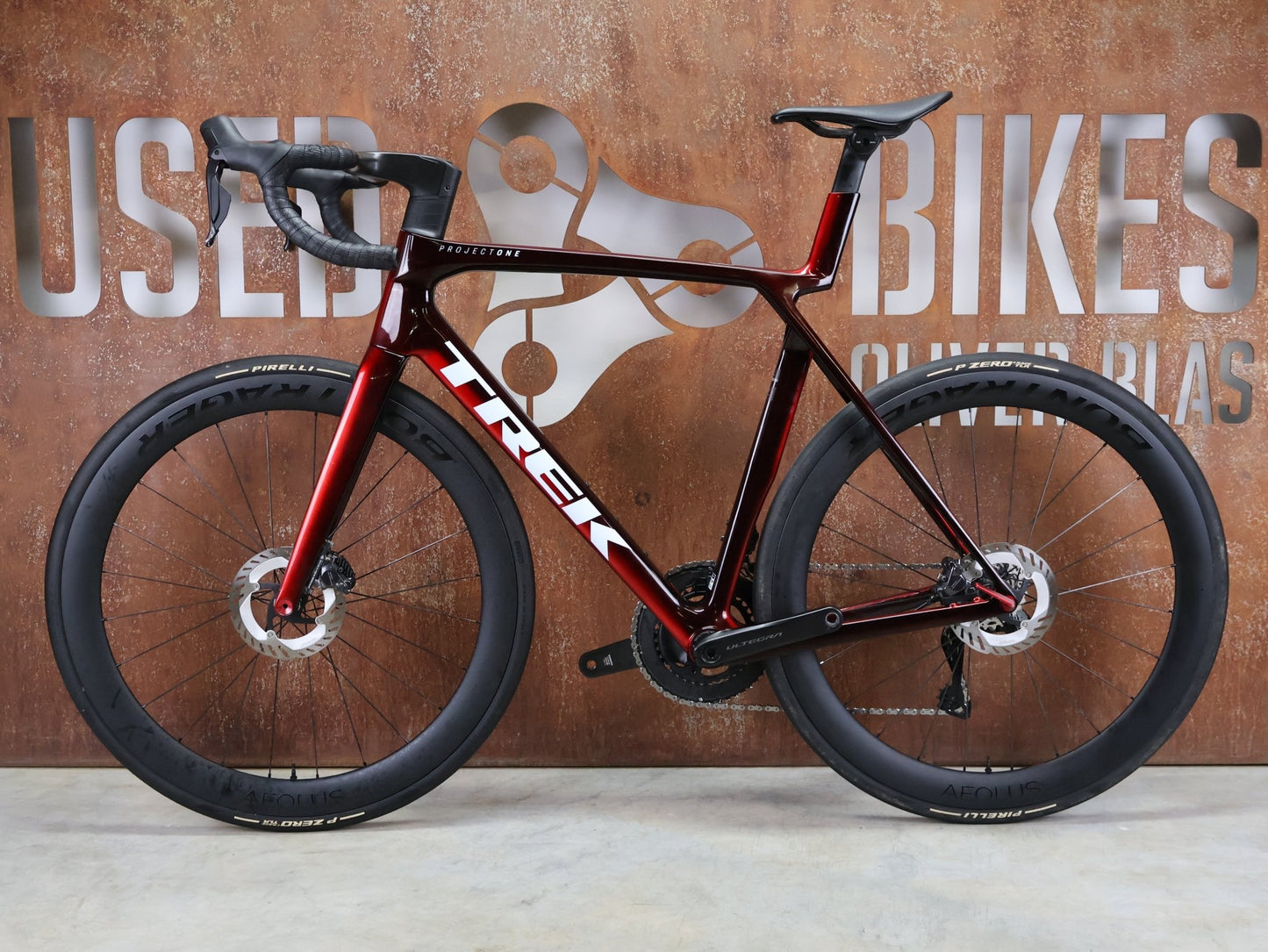 Rennrad von Trek, TREK MADONE SLR 7 GEN 8 / CARBON RED SMOKE / L vor USEDBIKES - OB.DE Hintergrund