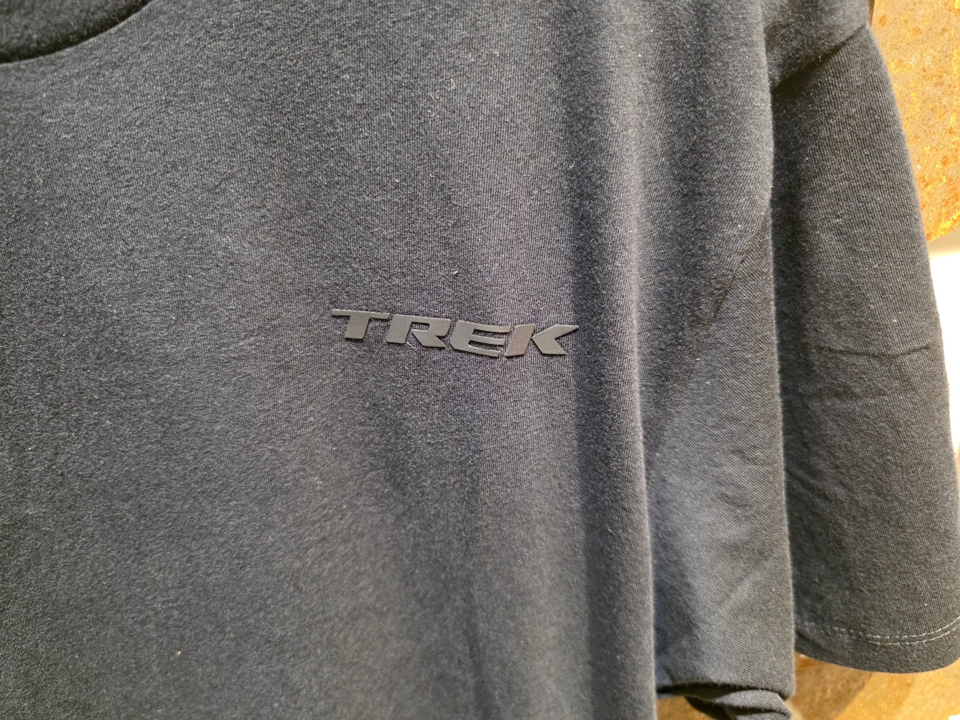 Freizeitbekleidung von Trek, TREK MONOCHROMATIC T - SHIRT / UNISEX vor USEDBIKES - OB.DE Hintergrund