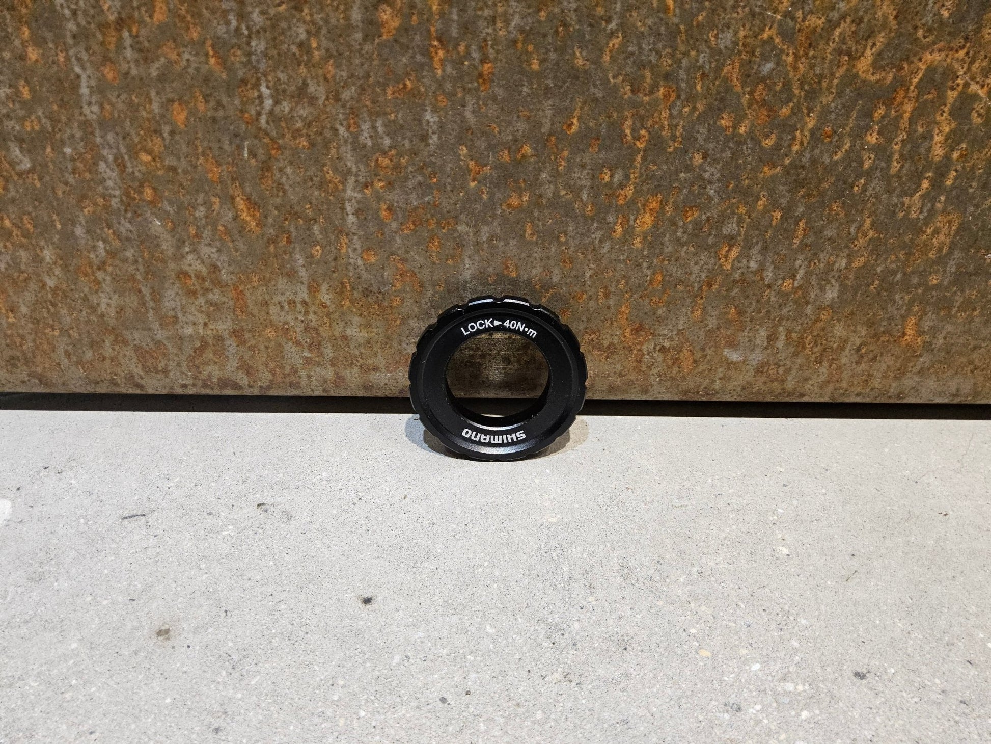 Bremsscheibe von Shimano, VERSCHLUSSRING SHIMANO CENTERLOCK BREMSSCHEIBE / SCHWARZ vor USEDBIKES - OB.DE Hintergrund