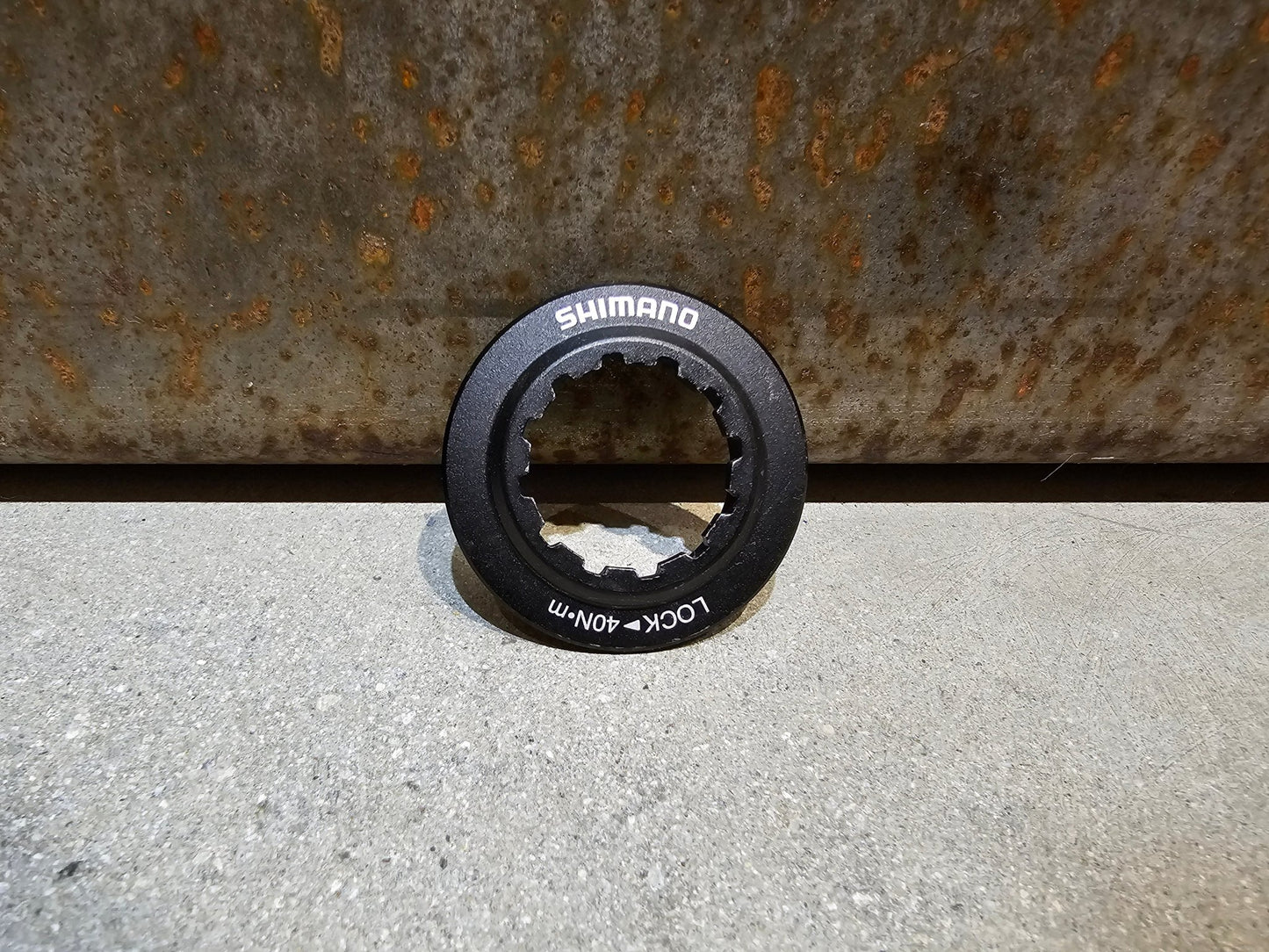 Bremsscheibe von Shimano, VERSCHLUSSRING SHIMANO CENTERLOCK BREMSSCHEIBE / SCHWARZ in variant_title vor USEDBIKES - OB.DE Hintergrund
