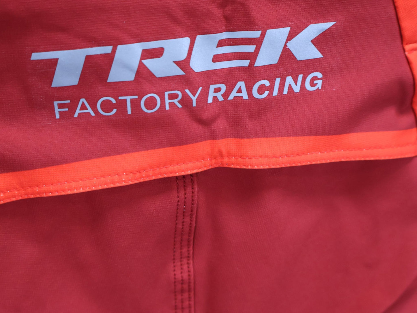 Hosen Herren von 100%, 100% – R - CORE X PANTS / ORANGE - RED / TREK FACTORY RACING TEAM / 4 - WAY STRETCH vor USEDBIKES - OB.DE Hintergrund