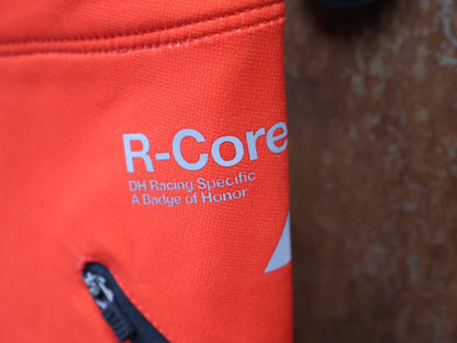 Hosen Herren von 100%, 100% – R - CORE X PANTS / ORANGE - RED / TREK FACTORY RACING TEAM / 4 - WAY STRETCH vor USEDBIKES - OB.DE Hintergrund