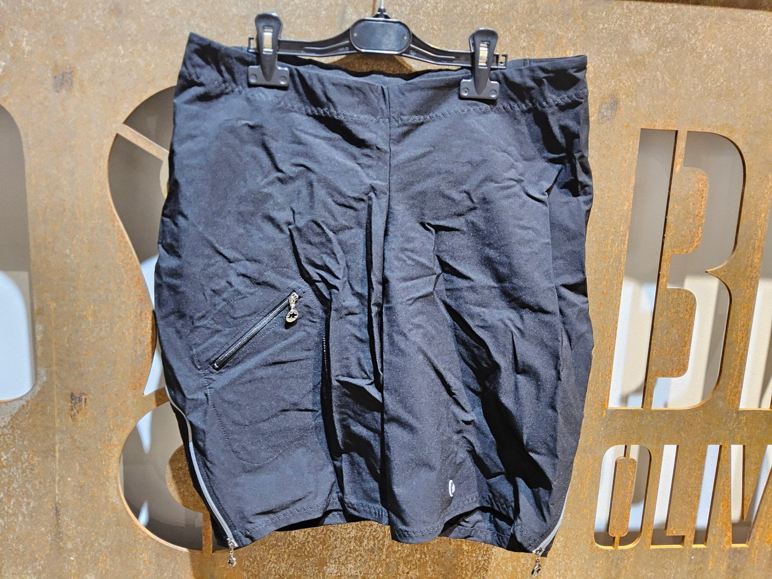Hosen Damen von Assos, ASSOS HLAALALAI CARGO SHORTS S7 / KURZE HOSE / DAMEN / BLACK SERIES in variant_title vor USEDBIKES - OB.DE Hintergrund