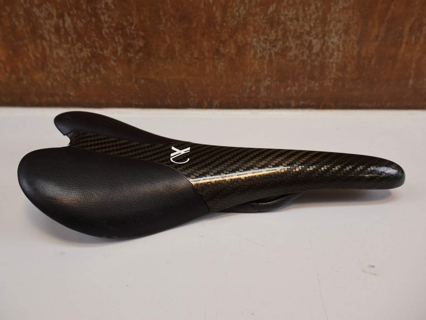 Sattel von AX Lightness, AX-LIGHTNESS ENDURANCE PLUS CARBON SATTEL / LEDER BEZUG / SCHWARZ / ULTRALEICHT 101G vor USEDBIKES-OB.DE Hintergrund