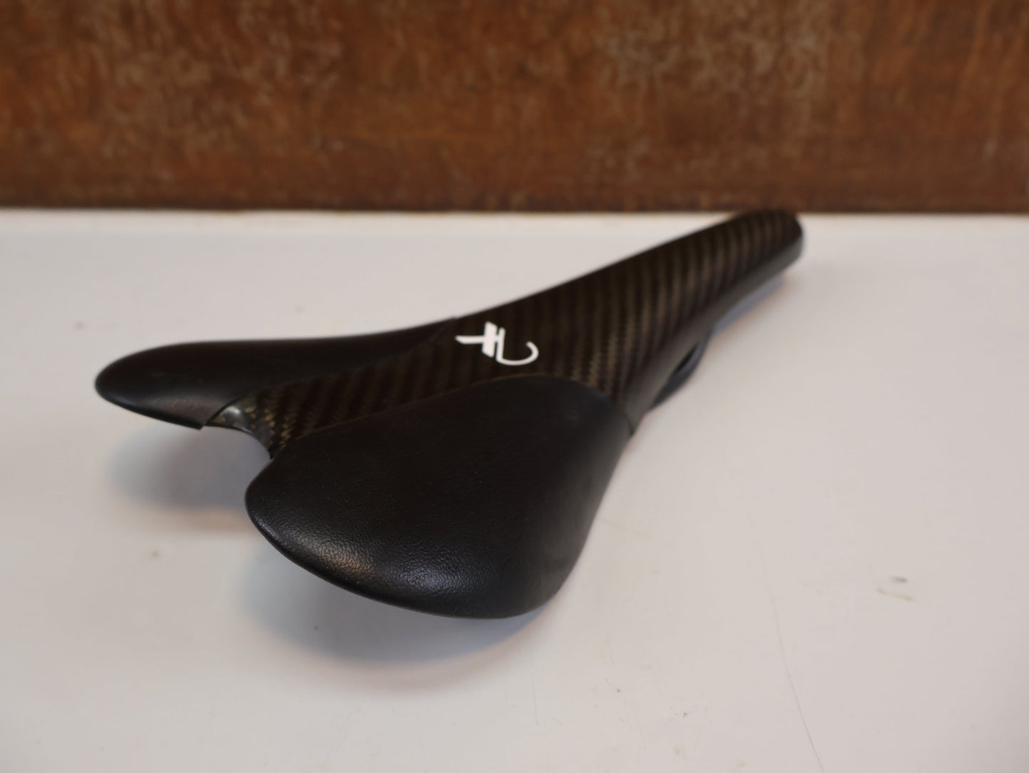 Sattel von AX Lightness, AX-LIGHTNESS ENDURANCE PLUS CARBON SATTEL / LEDER BEZUG / SCHWARZ / ULTRALEICHT 101G vor USEDBIKES-OB.DE Hintergrund