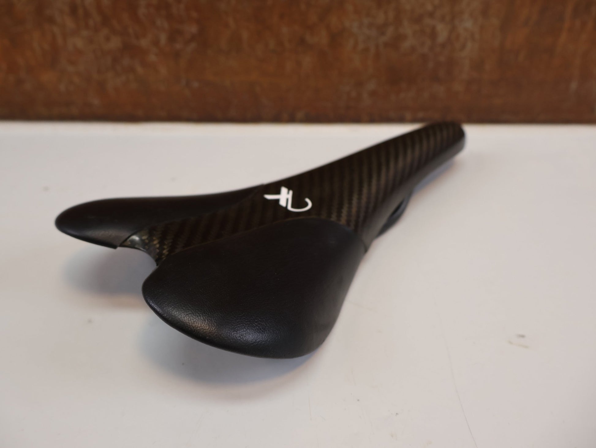Sattel von AX Lightness, AX-LIGHTNESS ENDURANCE PLUS CARBON SATTEL / LEDER BEZUG / SCHWARZ / ULTRALEICHT 101G vor USEDBIKES-OB.DE Hintergrund