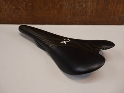 Sattel von AX Lightness, AX-LIGHTNESS ENDURANCE PLUS CARBON SATTEL / LEDER BEZUG / SCHWARZ / ULTRALEICHT 101G vor USEDBIKES-OB.DE Hintergrund