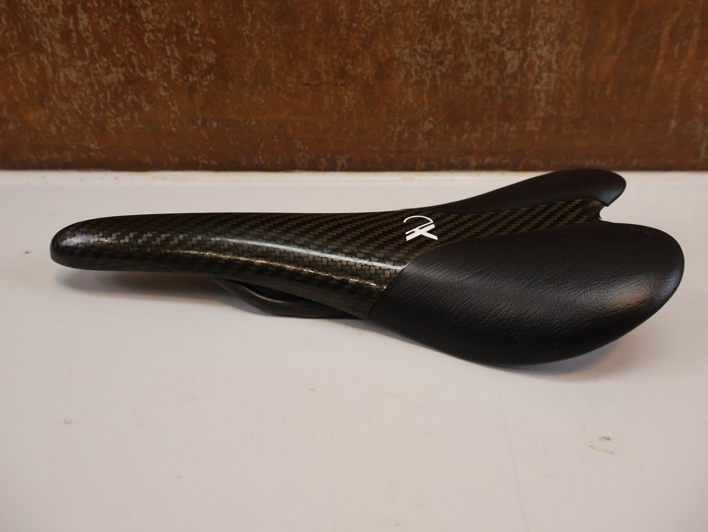 Sattel von AX Lightness, AX-LIGHTNESS ENDURANCE PLUS CARBON SATTEL / LEDER BEZUG / SCHWARZ / ULTRALEICHT 101G vor USEDBIKES-OB.DE Hintergrund