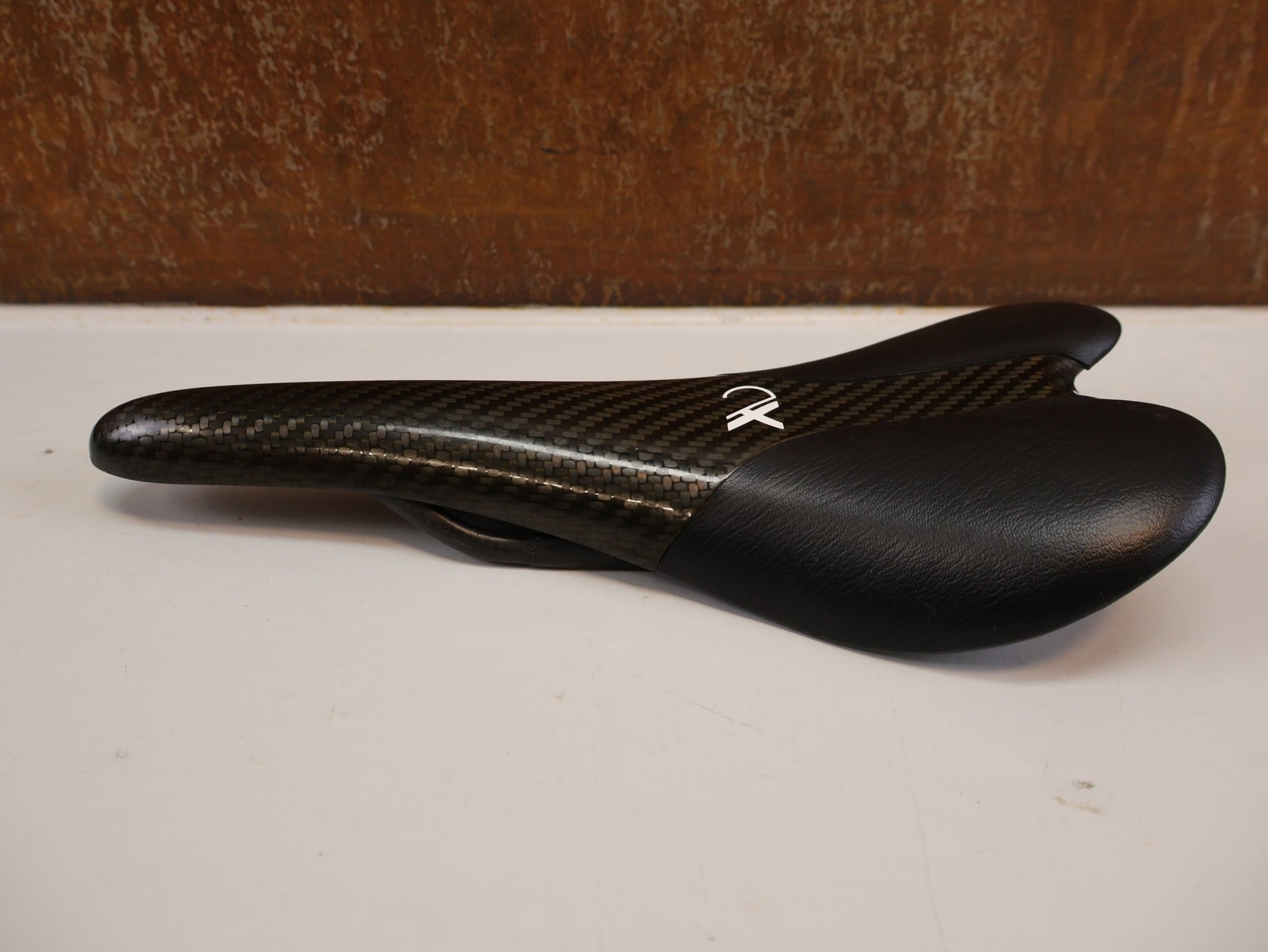Sattel von AX Lightness, AX-LIGHTNESS ENDURANCE PLUS CARBON SATTEL / LEDER BEZUG / SCHWARZ / ULTRALEICHT 101G vor USEDBIKES-OB.DE Hintergrund