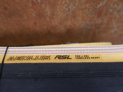 Reifen von Bontrager, BONTRAGER AEOLUS RSL TLR RENNRADREIFEN 700C X 28MM BLACK / TAN WALL vor USEDBIKES - OB.DE Hintergrund