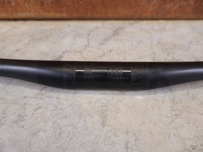 Lenker von Bontrager, BONTRAGER KOVEE XXX CARBON 35 MTB - LENKER – 700 MM – 0 MM RISE – CARBON SMOKE vor USEDBIKES - OB.DE Hintergrund