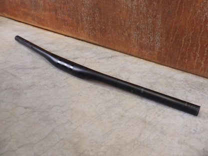 Lenker von Bontrager, BONTRAGER KOVEE XXX CARBON 35 MTB - LENKER – 700 MM – 0 MM RISE – CARBON SMOKE vor USEDBIKES - OB.DE Hintergrund