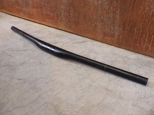 Lenker von Bontrager, BONTRAGER KOVEE XXX CARBON 35 MTB - LENKER – 700 MM – 0 MM RISE – CARBON SMOKE vor USEDBIKES - OB.DE Hintergrund