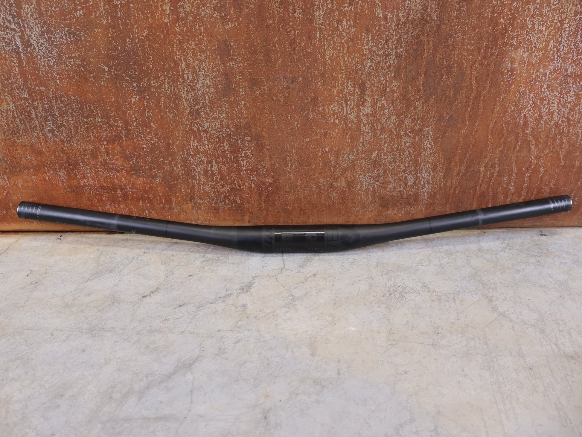 Lenker von Bontrager, BONTRAGER KOVEE XXX CARBON 35 MTB - LENKER – 700 MM – 0 MM RISE – CARBON SMOKE vor USEDBIKES - OB.DE Hintergrund