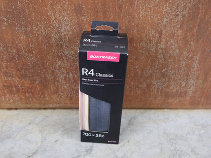 Reifen von Pirelli, BONTRAGER R4 CLASSICS HARD - CASE LITE RENNREIFEN / 700C X 28 MM – CLINCHER – 320 TPI – BLACK/NATUR vor USEDBIKES - OB.DE Hintergrund