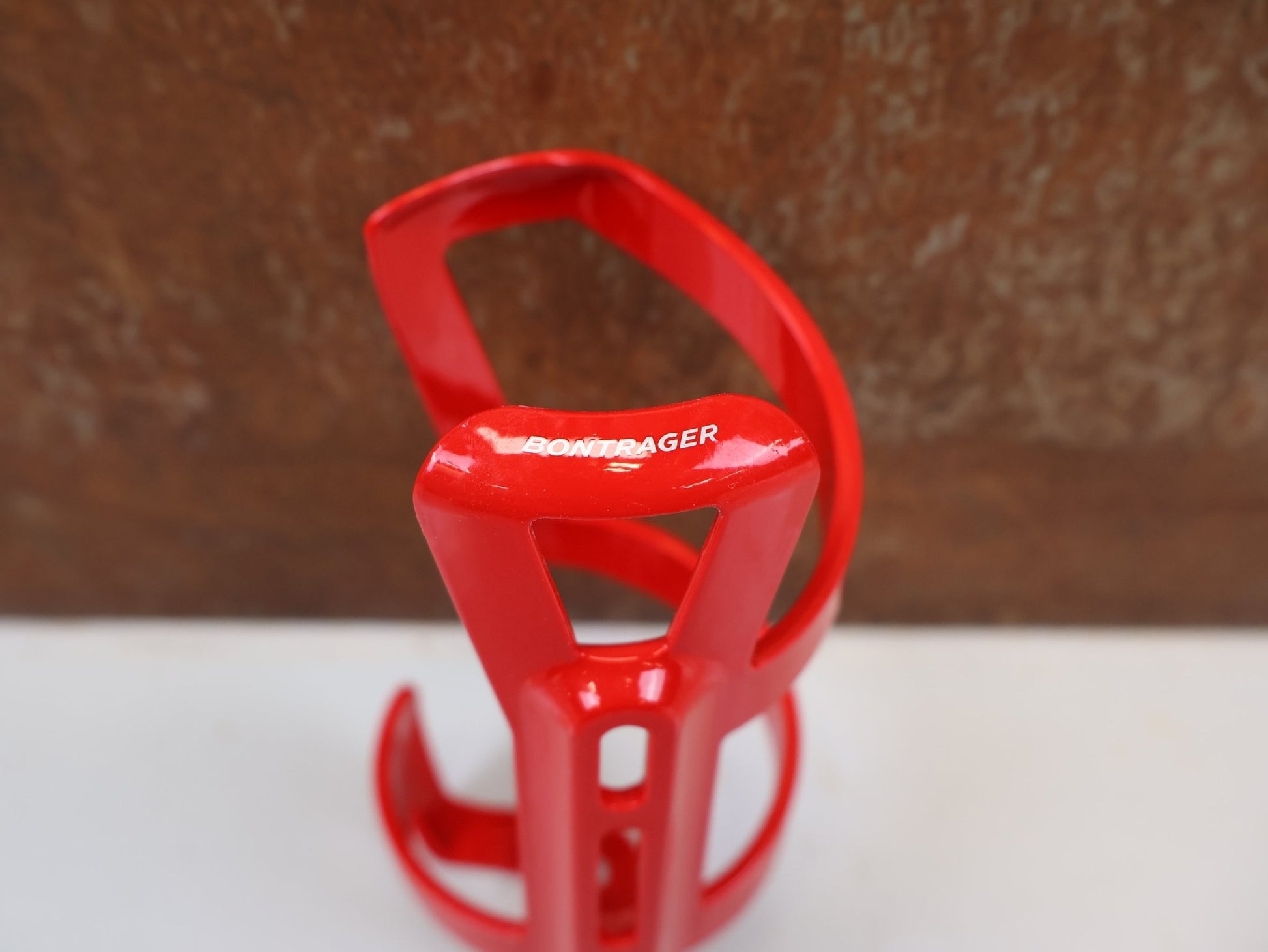 Trinkflaschen und Halter von Bontrager, BONTRAGER RIGHT SIDE LOAD FLASCHENHALTER RED RECYCLED vor USEDBIKES-OB.DE Hintergrund