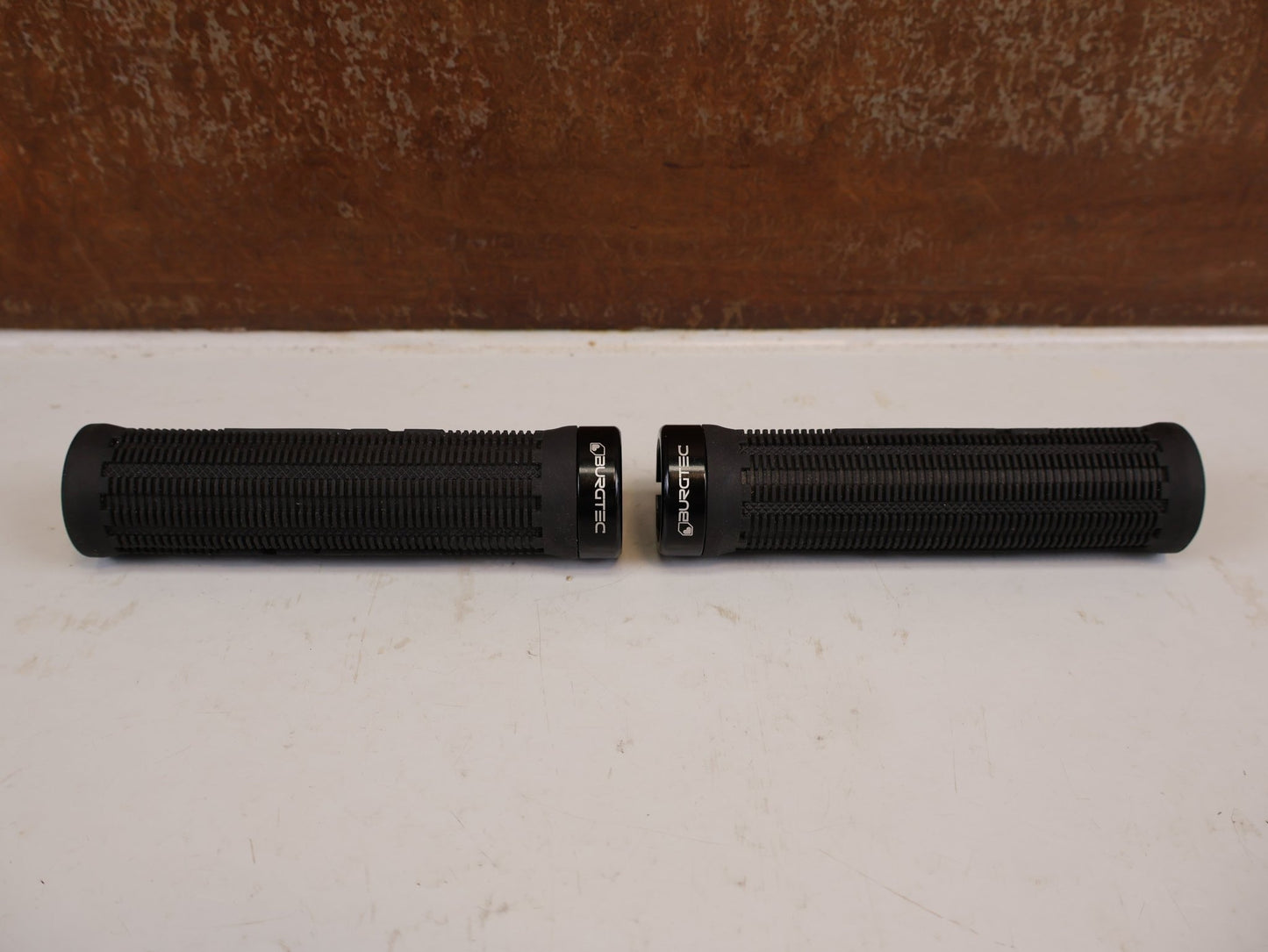 Griffe und Lenkerbänder von Burgtec, BURGTEC BARTENDER PRO GREG MINNAAR SIGNATURE GRIFFE 31.5MM vor USEDBIKES-OB.DE Hintergrund