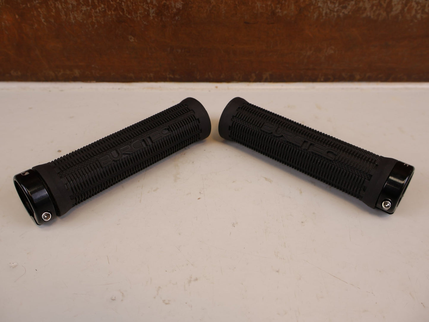 Griffe und Lenkerbänder von Burgtec, BURGTEC BARTENDER PRO GREG MINNAAR SIGNATURE GRIFFE 31.5MM vor USEDBIKES-OB.DE Hintergrund