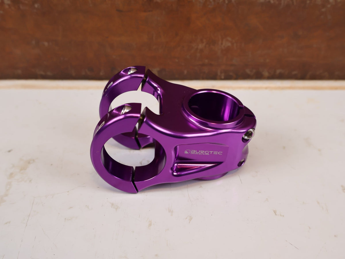 Vorbau von Burgtec, Burgtec Enduro MK3 Vorbau 35mm Klemmung 42.5mm Purple Rain vor USEDBIKES-OB.DE Hintergrund