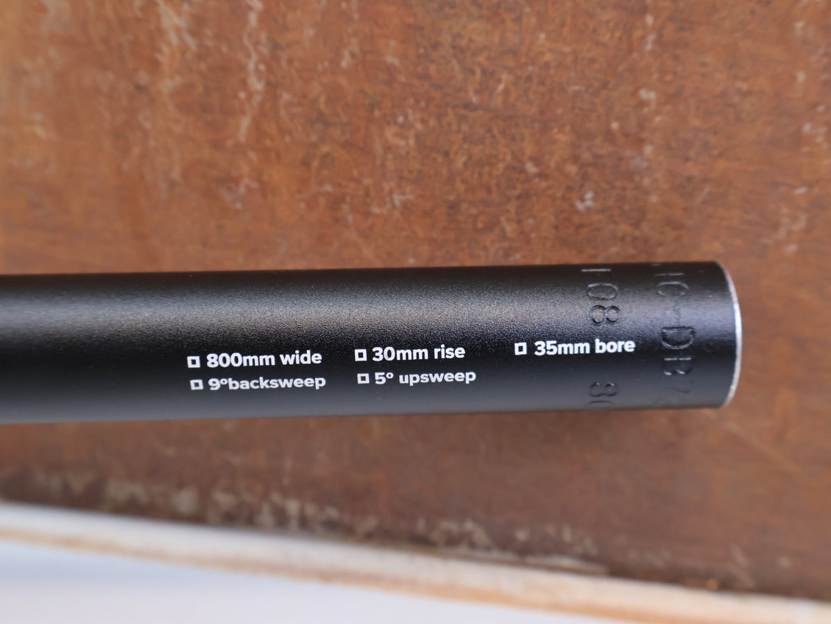 Lenker von Burgtec, Burgtec Ride Wide Alloy DH Lenker 35mm 30mm Rise 770mm vor USEDBIKES-OB.DE Hintergrund