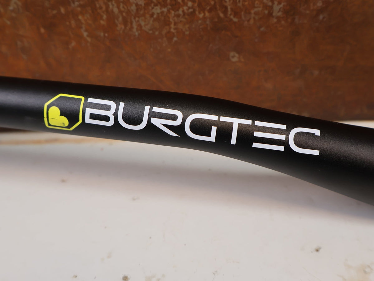 Lenker von Burgtec, Burgtec Ride Wide Alloy DH Lenker 35mm 30mm Rise 770mm vor USEDBIKES-OB.DE Hintergrund