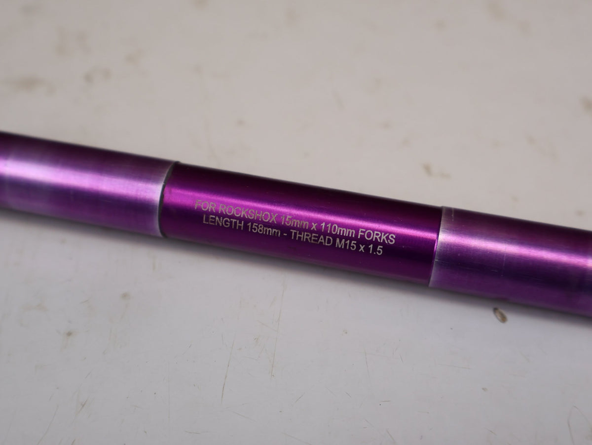 Zubehör von Burgtec, Burgtec RockShox Boost Steckachse 15x110mm Purple Rain 158mm vor USEDBIKES-OB.DE Hintergrund