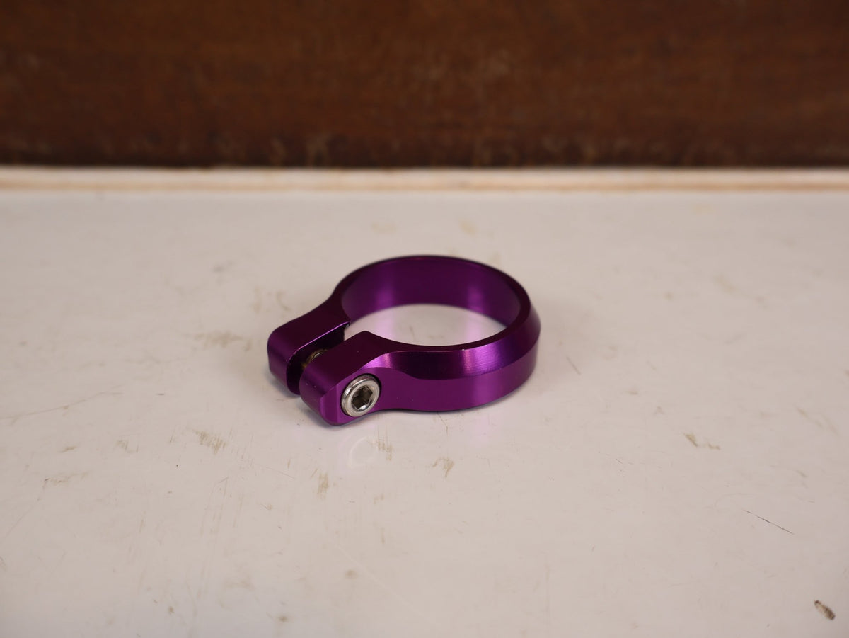 Zubehör von Burgtec, Burgtec Sattelklemme 39.7mm Purple Rain MTB 10574 vor USEDBIKES-OB.DE Hintergrund