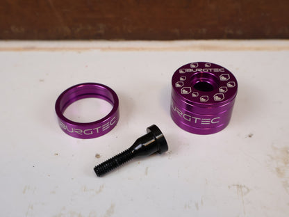 Vorbau von Burgtec, Burgtec Spacer Set Top Cap + Bolt Purple Rain Schwarz vor USEDBIKES-OB.DE Hintergrund