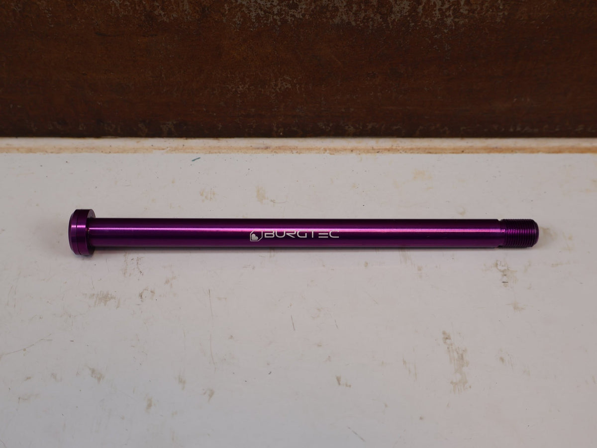 Zubehör von Burgtec, Burgtec Trek Steckachse 184.5mm M12x1.0 Purple Rain 10104 vor USEDBIKES-OB.DE Hintergrund