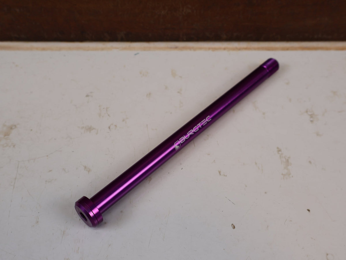 Zubehör von Burgtec, Burgtec Trek Steckachse 184.5mm M12x1.0 Purple Rain 10104 vor USEDBIKES-OB.DE Hintergrund