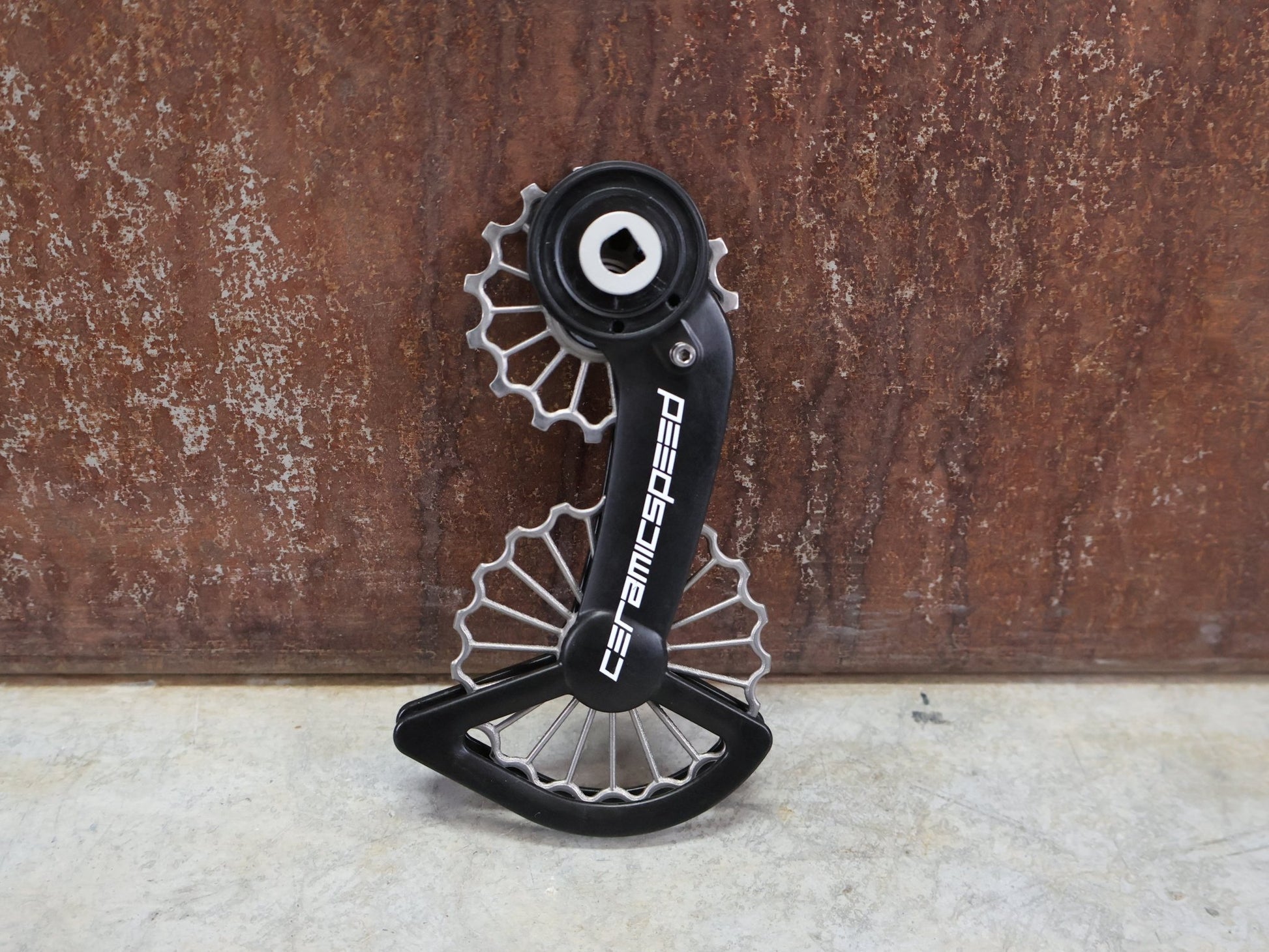 Schaltungsteile von Ceramicspeed, CERAMICSPEED OSPW 3D PRINTED HOLLOW TITANIUM SRAM RED / FORCE AXS vor USEDBIKES - OB.DE Hintergrund