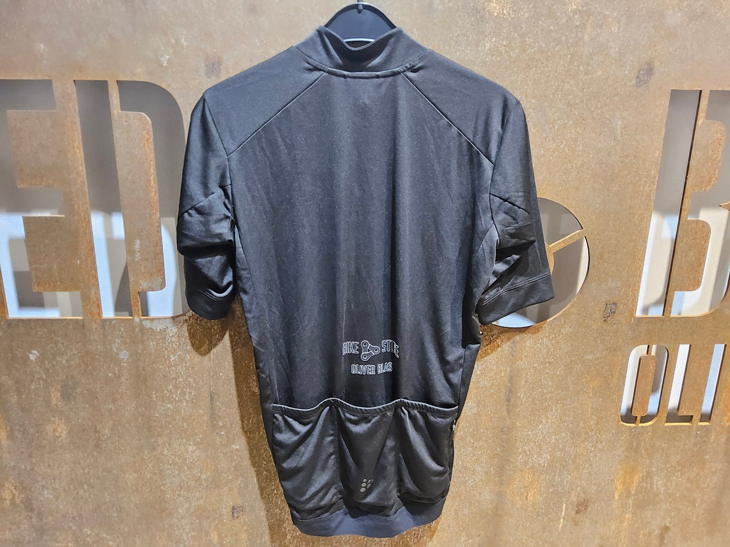 Trikot Herren von Craft, CRAFT ESSENCE BIKESTORE SS JERSEY - HERREN - KURZARM TRIKOT - BLACK in variant_title vor USEDBIKES - OB.DE Hintergrund