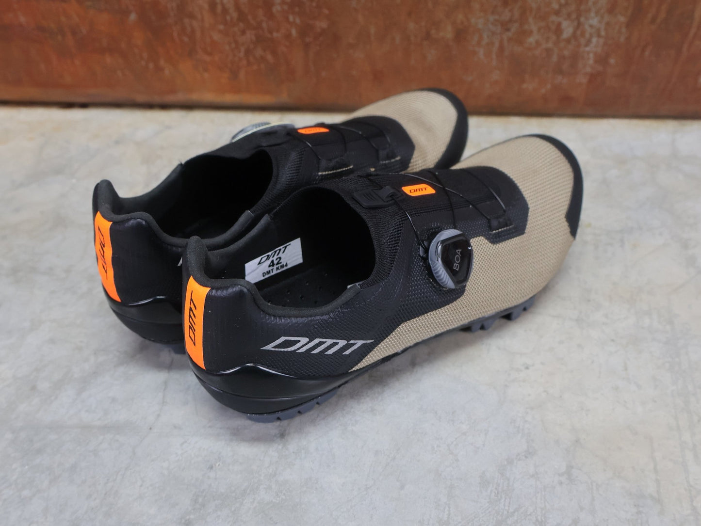 MTB - Herrenschuhe von Dmt, DMT KM4 MOUNTAINBIKESCHUH / SCHWARZ / BRONZE / UNISEX vor USEDBIKES - OB.DE Hintergrund