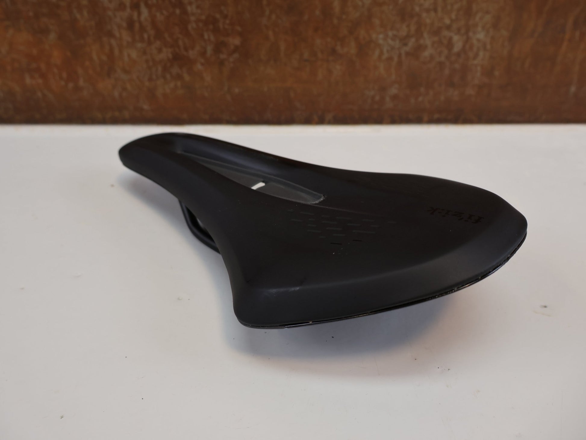 Sattel von Fizik, FIZIK TERRA ARGO X3 SATTEL / 150MM / GRAVEL & ALLROAD / KIUM - STREBEN / SCHWARZ vor USEDBIKES - OB.DE Hintergrund