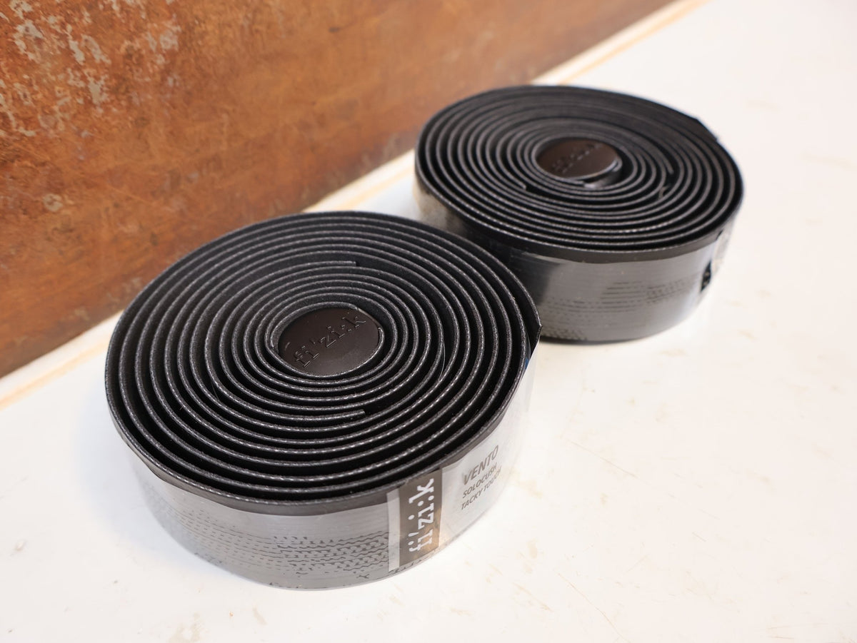 Griffe und Lenkerbänder von Supacaz, FIZIK VENTO SOLOCUSH TACKY LENKERBAND 2.7MM BLACK vor USEDBIKES-OB.DE Hintergrund