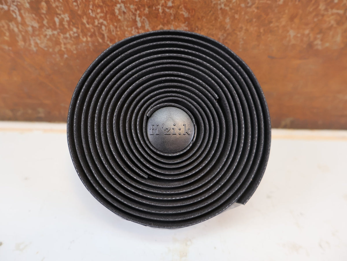 Griffe und Lenkerbänder von Supacaz, FIZIK VENTO SOLOCUSH TACKY LENKERBAND 2.7MM BLACK vor USEDBIKES-OB.DE Hintergrund