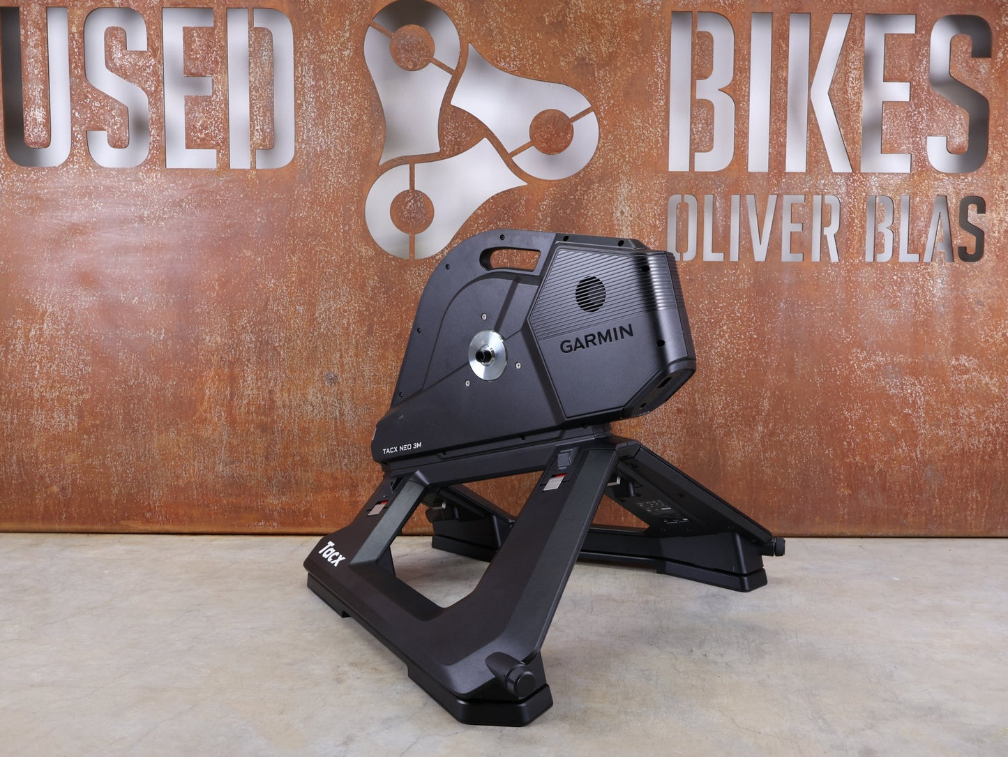 Rollentrainer & Zubehör von Garmin, GARMIN TACX NEO 3M HEIMTRAINER – SMART TRAINER MIT DIREKTANTRIEB vor USEDBIKES - OB.DE Hintergrund