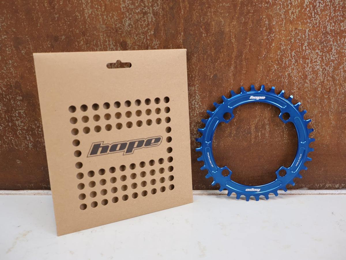 Kettenblatt von Hope, HOPE KETTENBLATT 104 BCD 36 ZÄHNE BLAU 4-ARM RR3622B vor USEDBIKES-OB.DE Hintergrund