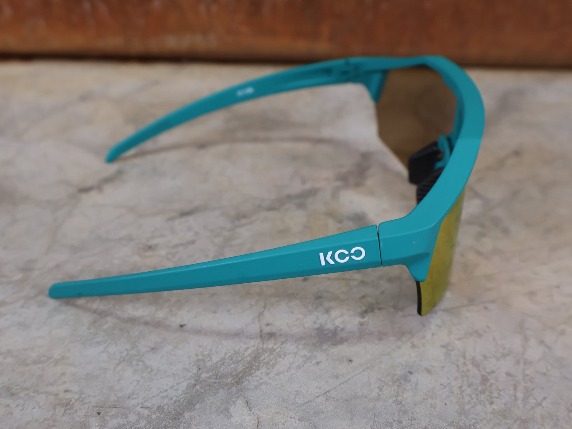 Brillen von Koo, KOO ALIBI BRILLE – PERSIAN GREEN MATT / ORANGE MIRROR vor USEDBIKES - OB.DE Hintergrund