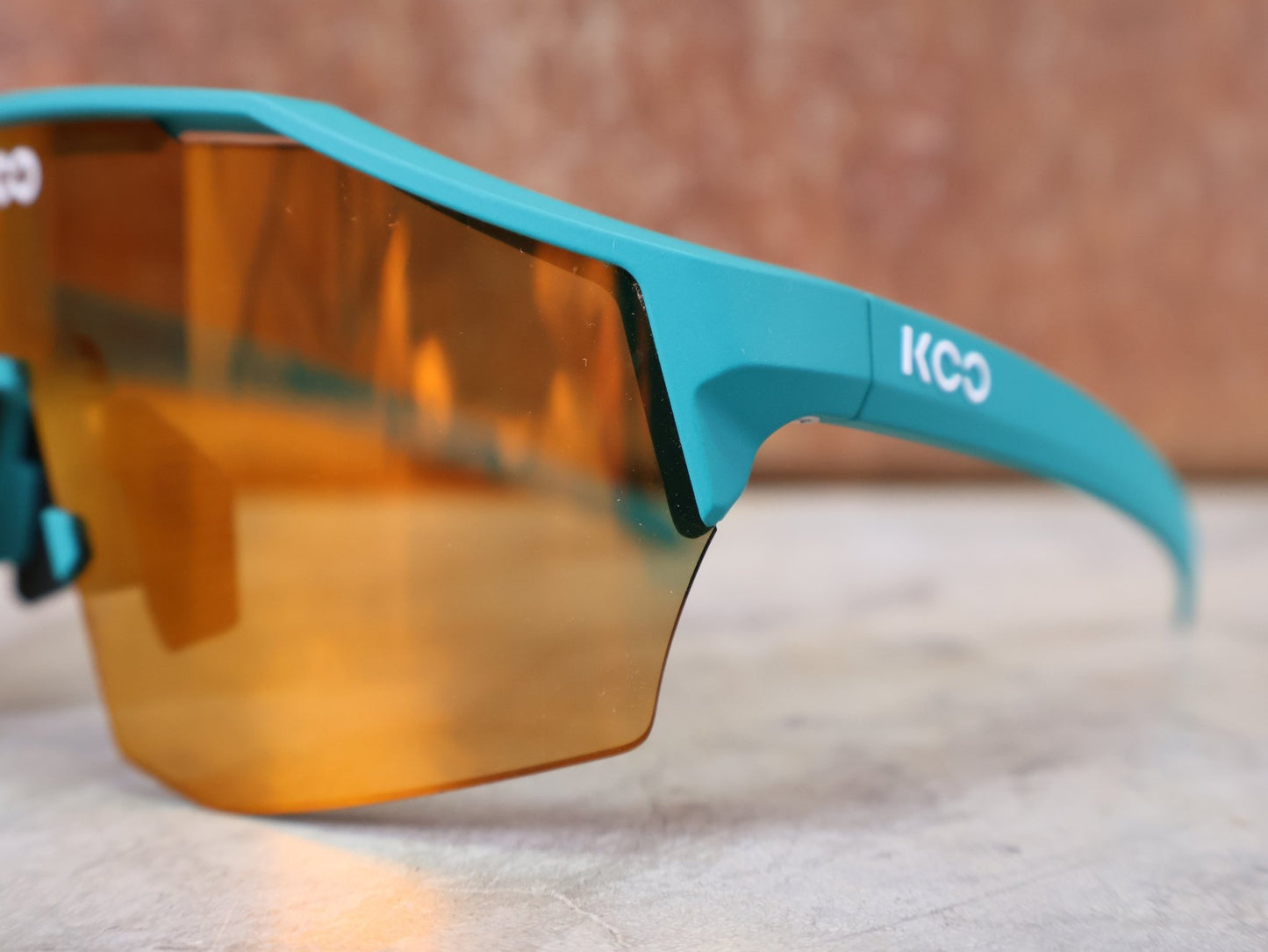Brillen von Koo, KOO ALIBI BRILLE – PERSIAN GREEN MATT / ORANGE MIRROR vor USEDBIKES - OB.DE Hintergrund