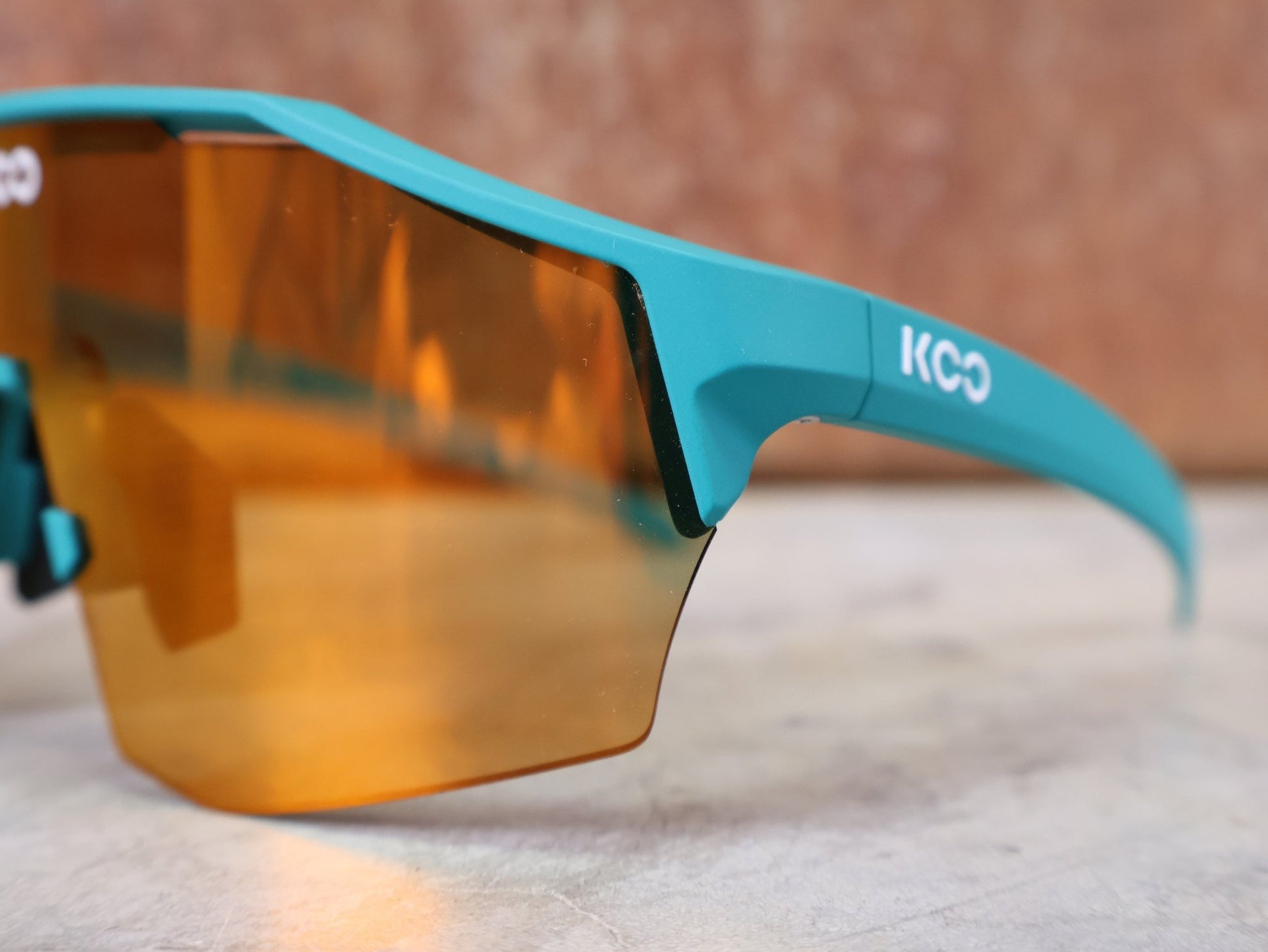 Brillen von Koo, KOO ALIBI BRILLE – PERSIAN GREEN MATT / ORANGE MIRROR vor USEDBIKES - OB.DE Hintergrund
