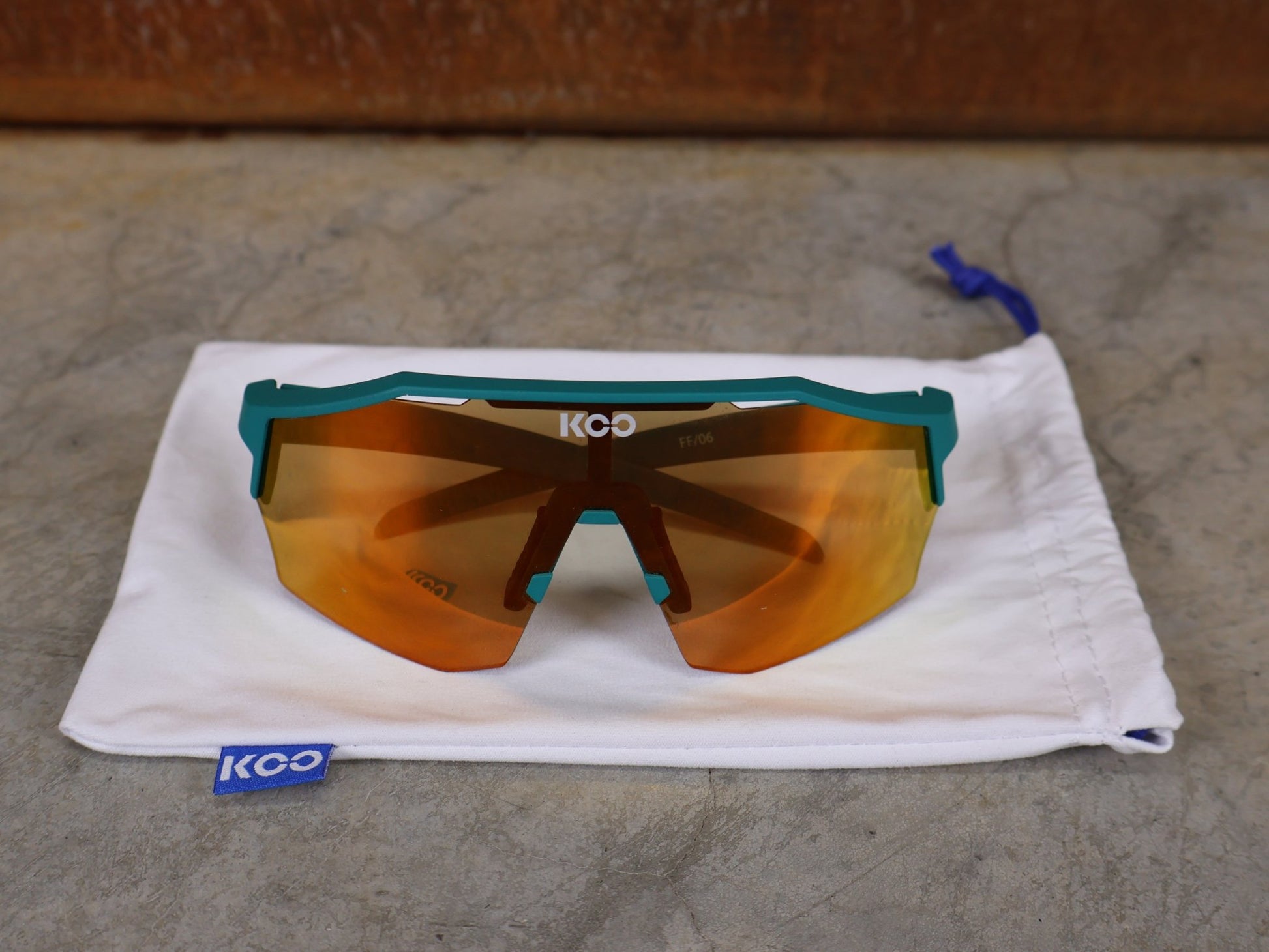 Brillen von Koo, KOO ALIBI BRILLE – PERSIAN GREEN MATT / ORANGE MIRROR vor USEDBIKES - OB.DE Hintergrund