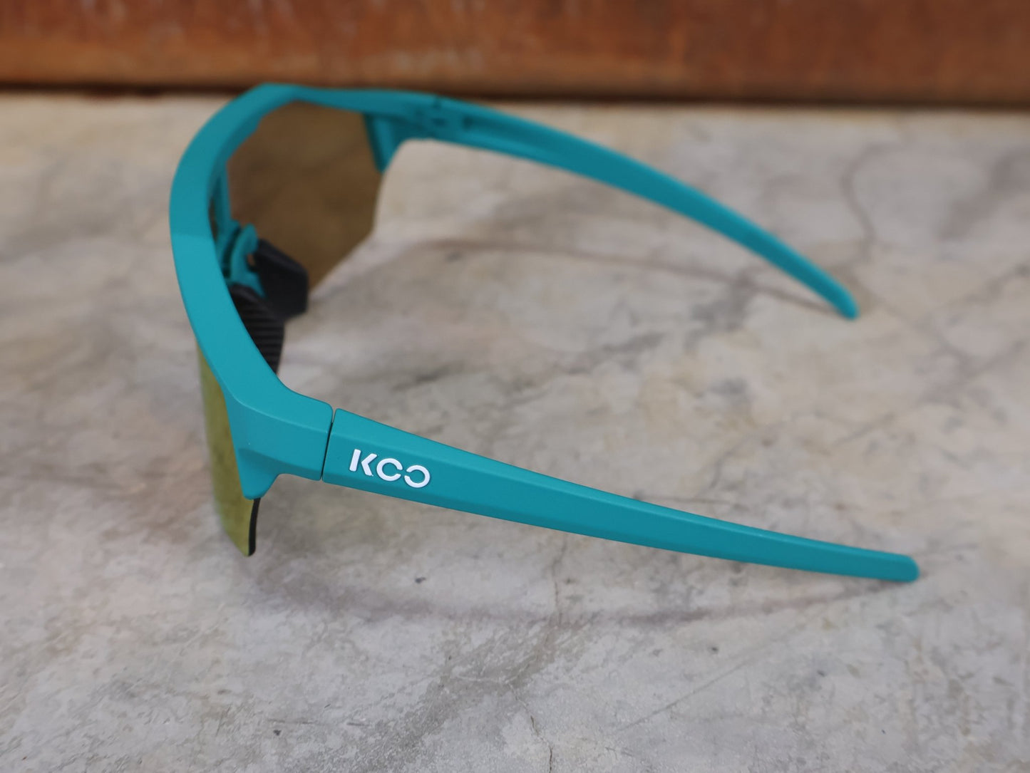 Brillen von Koo, KOO ALIBI BRILLE – PERSIAN GREEN MATT / ORANGE MIRROR vor USEDBIKES - OB.DE Hintergrund