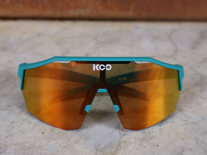 Brillen von Koo, KOO ALIBI BRILLE – PERSIAN GREEN MATT / ORANGE MIRROR vor USEDBIKES - OB.DE Hintergrund