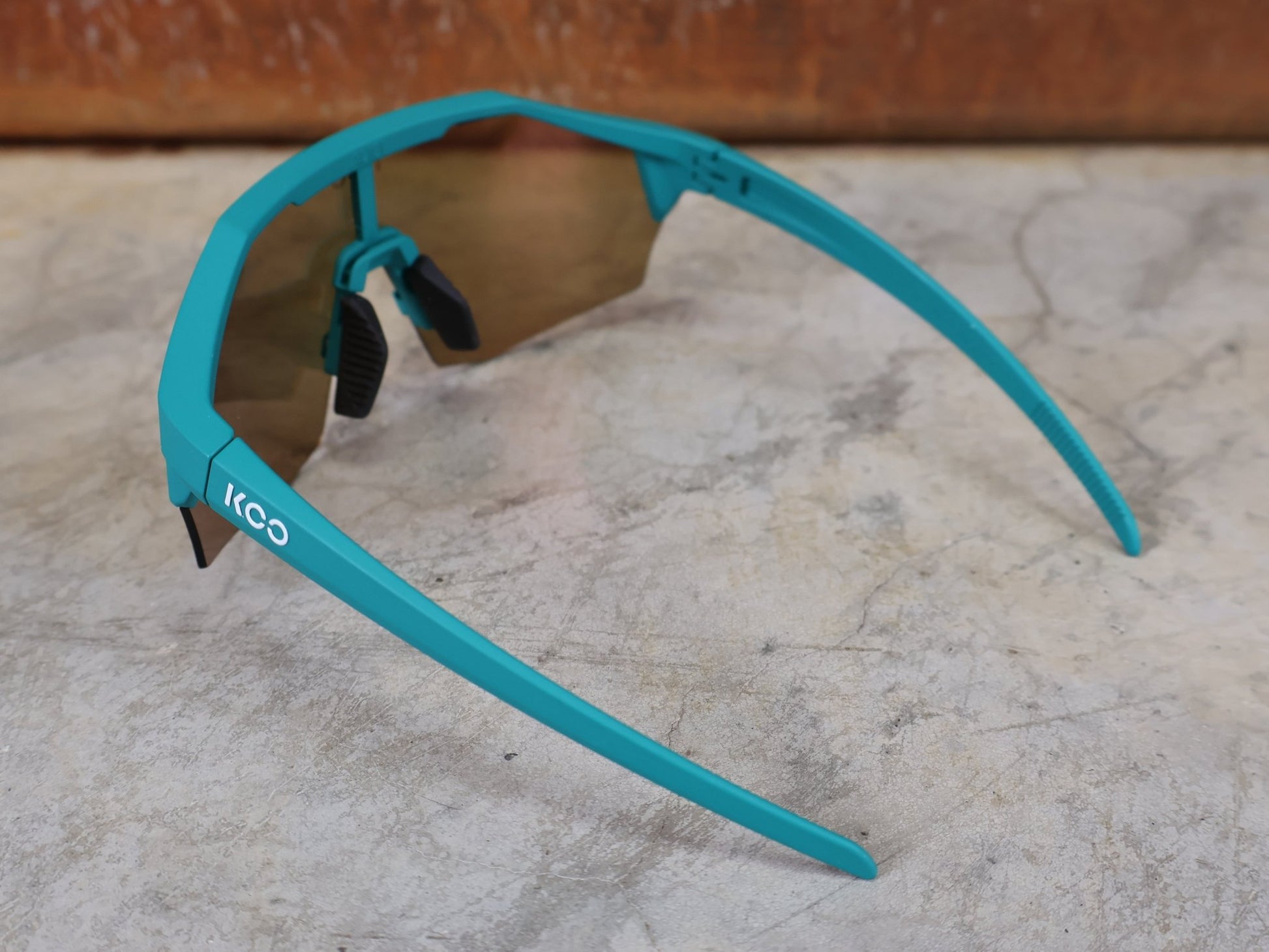 Brillen von Koo, KOO ALIBI BRILLE – PERSIAN GREEN MATT / ORANGE MIRROR vor USEDBIKES - OB.DE Hintergrund