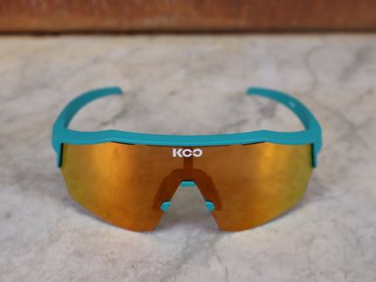 Brillen von Koo, KOO ALIBI BRILLE – PERSIAN GREEN MATT / ORANGE MIRROR vor USEDBIKES - OB.DE Hintergrund